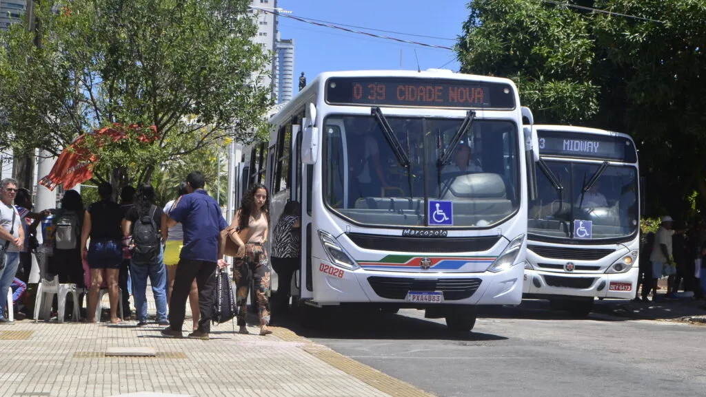 Ônibus do transporte público circulando em avenida comercial de Natal